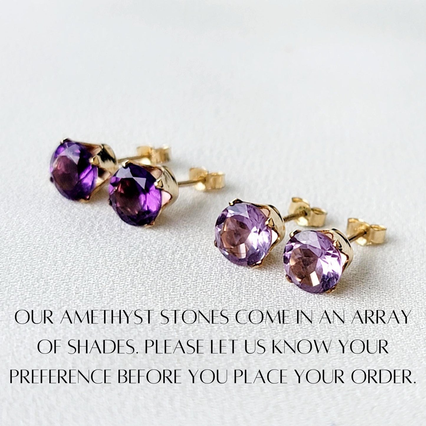 Three pairs of amethyst stud earrings with gold settings. The amethyst stones are different shades of purple. The text below the earrings reads: &#39;OUR AMETHYST STONES COME IN AN ARRAY OF SHADES. PLEASE LET US KNOW YOUR PREFERENCE BEFORE YOU PLACE YOUR ORDER.&#39;