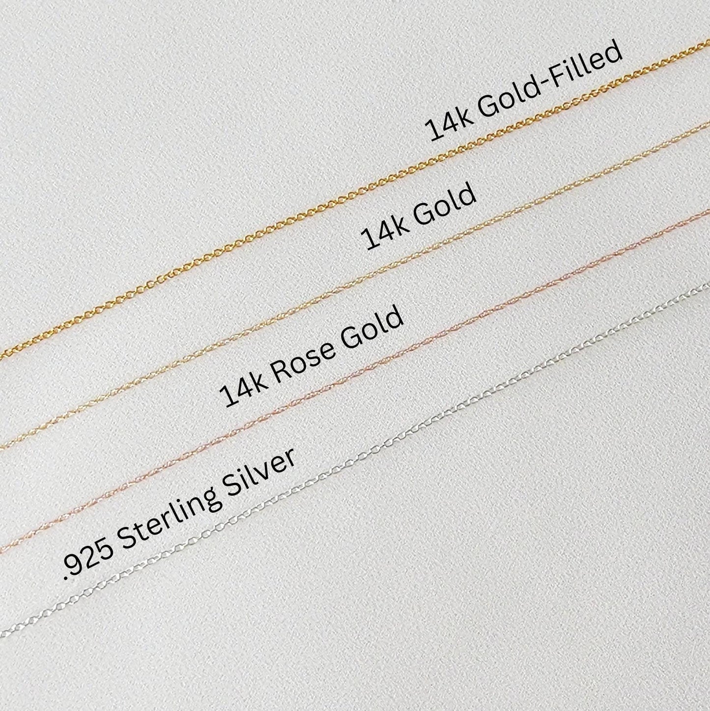 Four chains of different metals: .925 Sterling Silver, 14k Rose Gold, 14k Gold, and 14k Gold-Filled. The chains are laid out horizontally on a white surface, with the silver chain at the bottom and the gold-filled chain at the top.