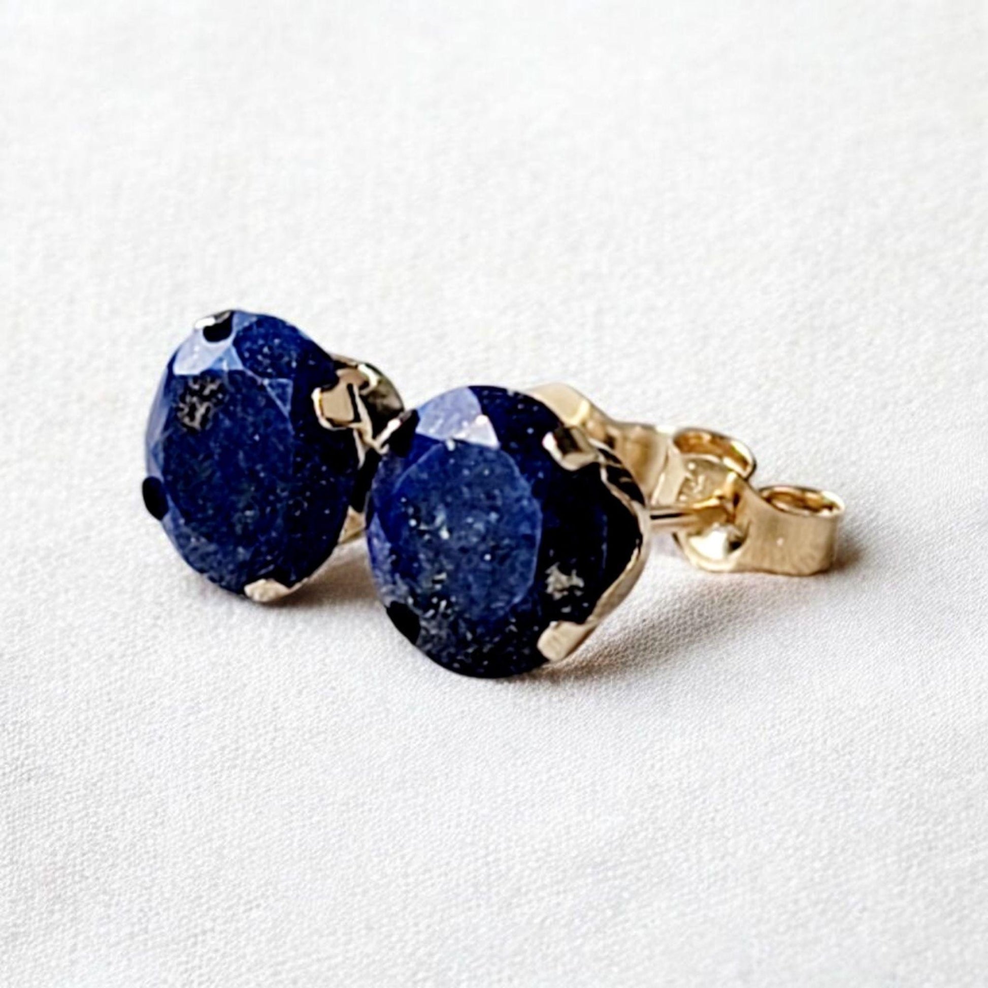 Close-up of round lapis lazuli gemstone stud earrings set in 14k solid gold or silver, small minimalist studs in 3mm, 4mm, 5mm, and 6mm.