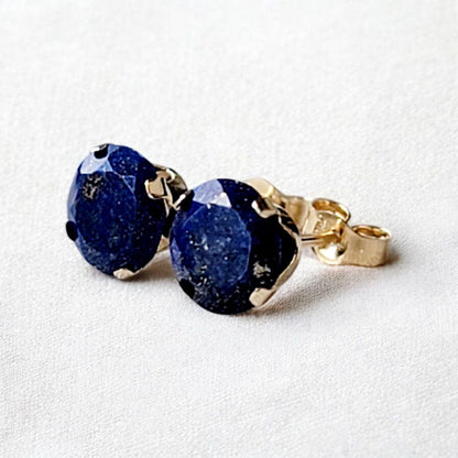 Close-up of round lapis lazuli gemstone stud earrings set in 14k solid gold or silver, small minimalist studs in 3mm, 4mm, 5mm, and 6mm.