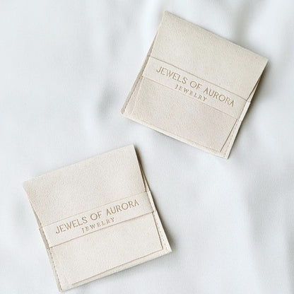 Two white, suede jewelry pouches with the text &#39;Jewels of Aurora Jewelry&#39; printed on them.