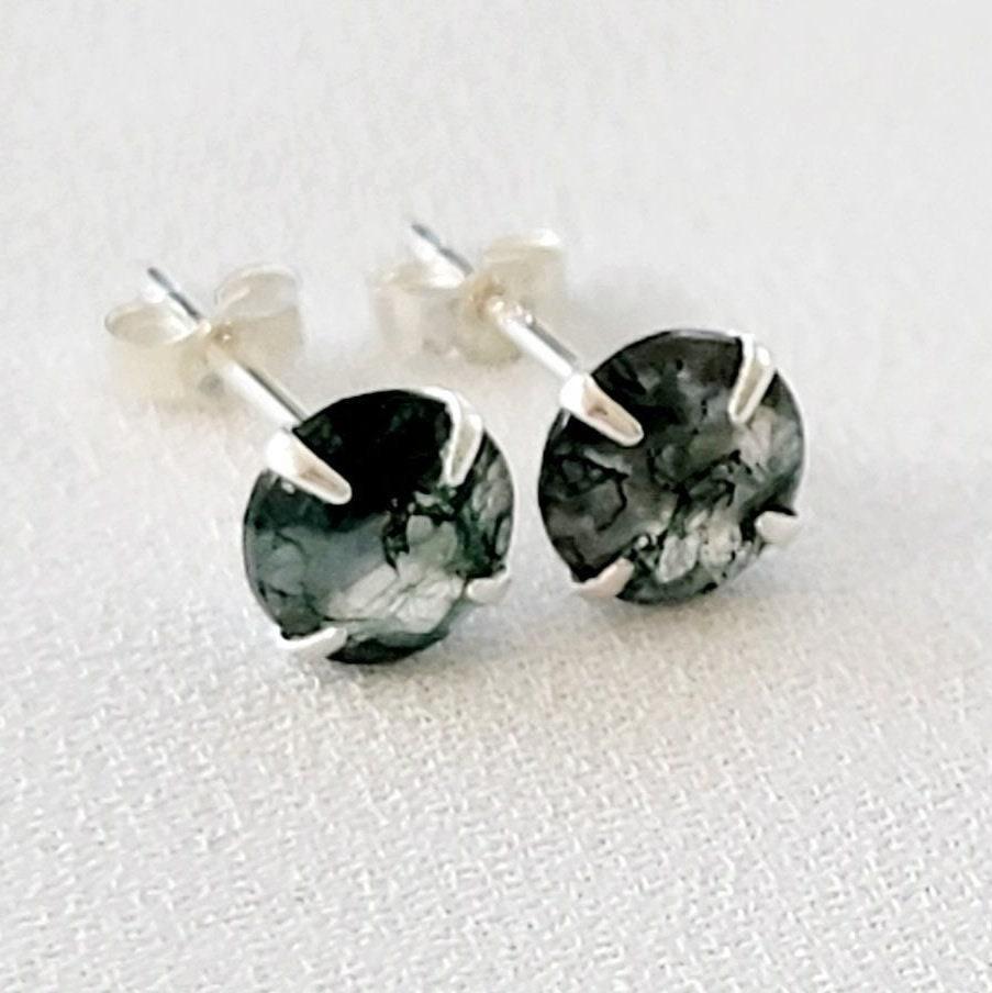 A pair of silver stud earrings with round green moss agate stones. The stones have a marbled pattern from the moss growing through the clear crystal.