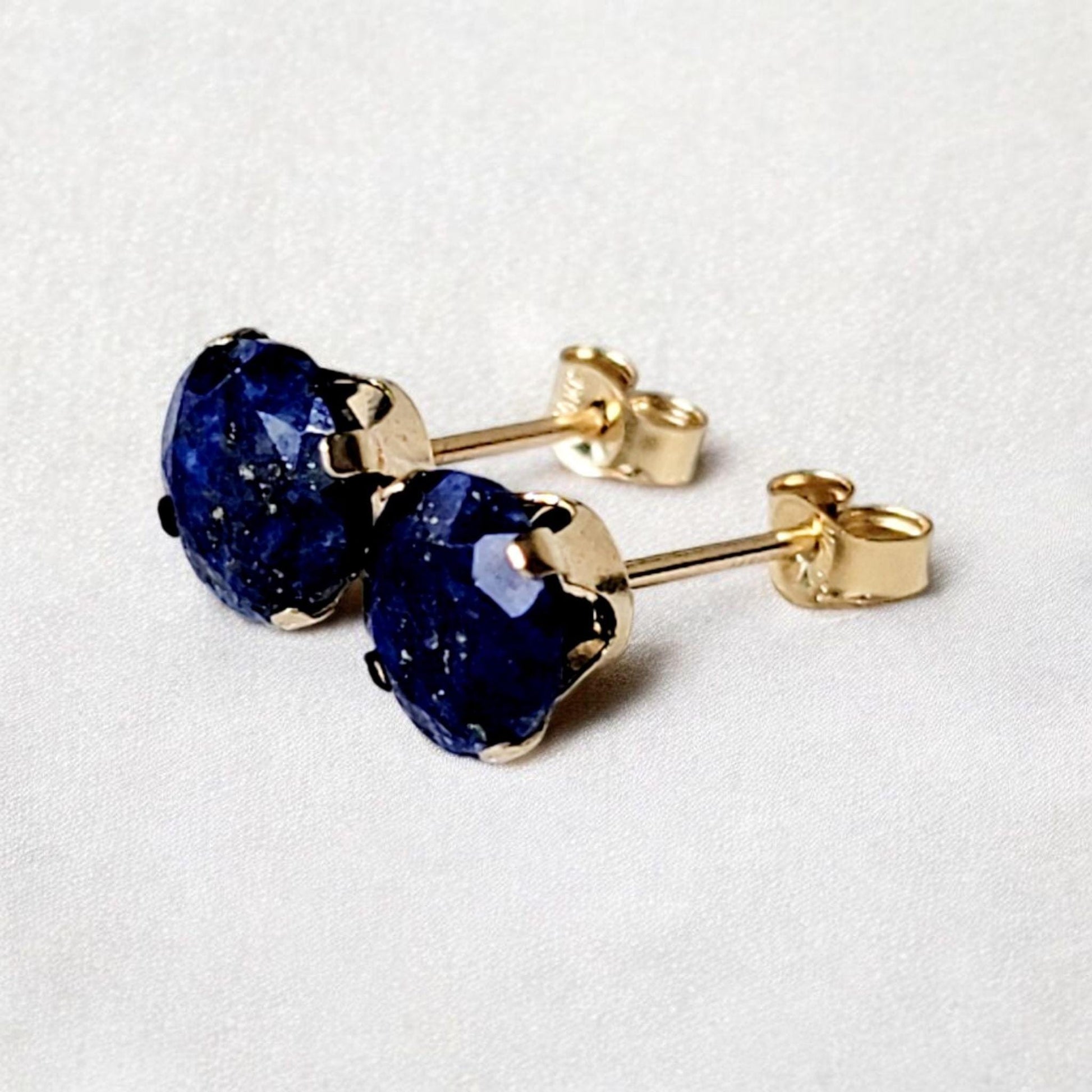 Close-up of round lapis lazuli gemstone stud earrings set in 14k solid gold or silver, small minimalist studs in 3mm, 4mm, 5mm, and 6mm.