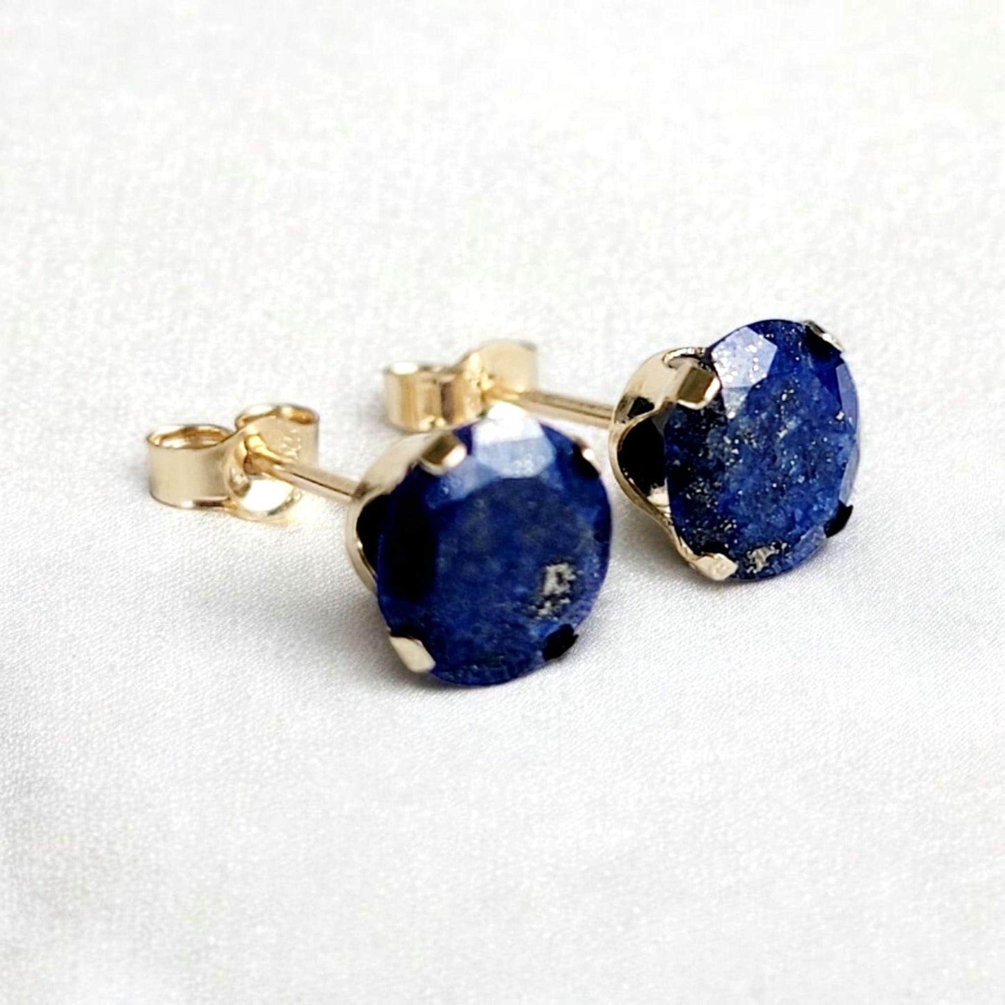 Close-up of round lapis lazuli gemstone stud earrings set in 14k solid gold or silver, small minimalist studs in 3mm, 4mm, 5mm, and 6mm.